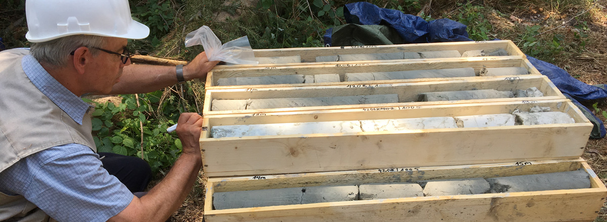 Ein Geologe beschriftet die mit Bohrkernen gefüllten Holzkisten.